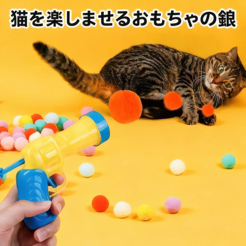 黄色の背景で猫用ボールランチャーから放たれたボールを追いかけて楽しそうに遊ぶトラ猫。室内猫の運動不足とストレスを解消し、野生の本能を呼び覚ますおもちゃの銃のイメージ。
